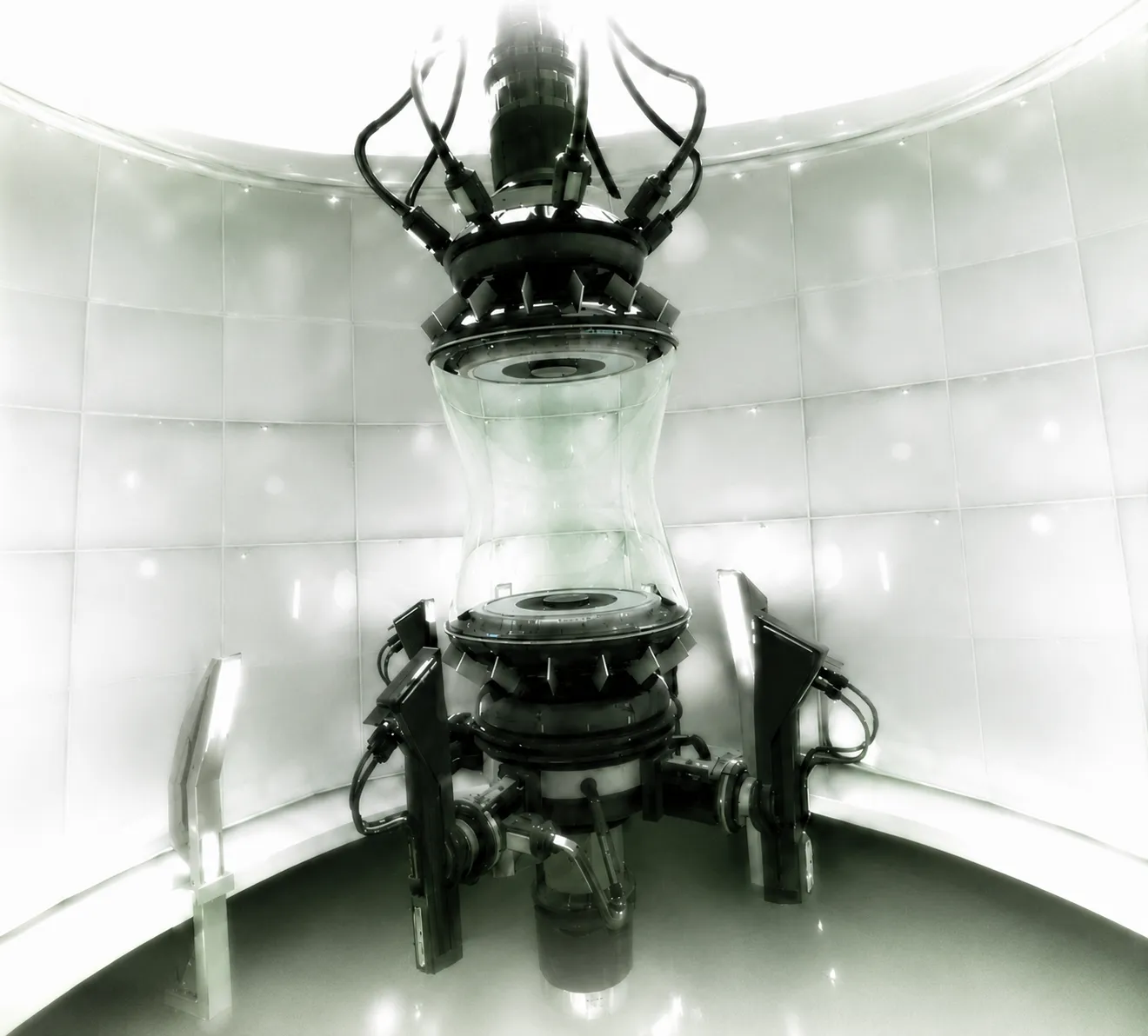 A tall futuristic reactor machine inside a curved white chamber